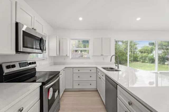 a kitchen with a sink stove and microwave