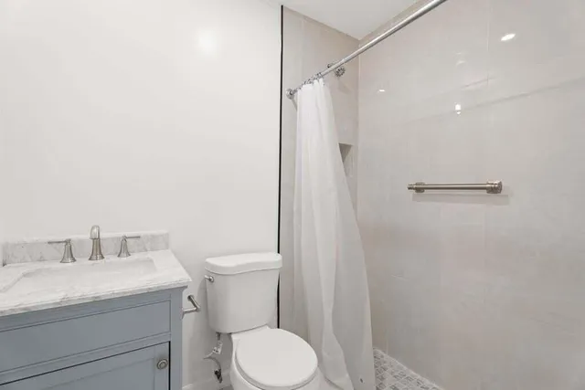 a bathroom with a granite countertop sink toilet and shower