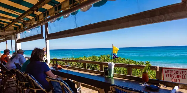 a view of house and ocean from a balcony