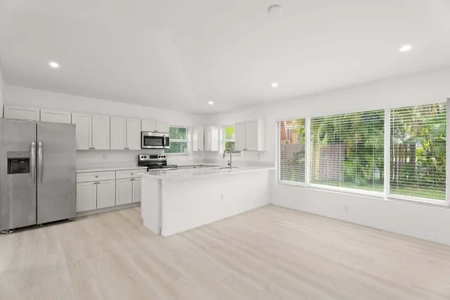 a kitchen with white cabinets and white appliances