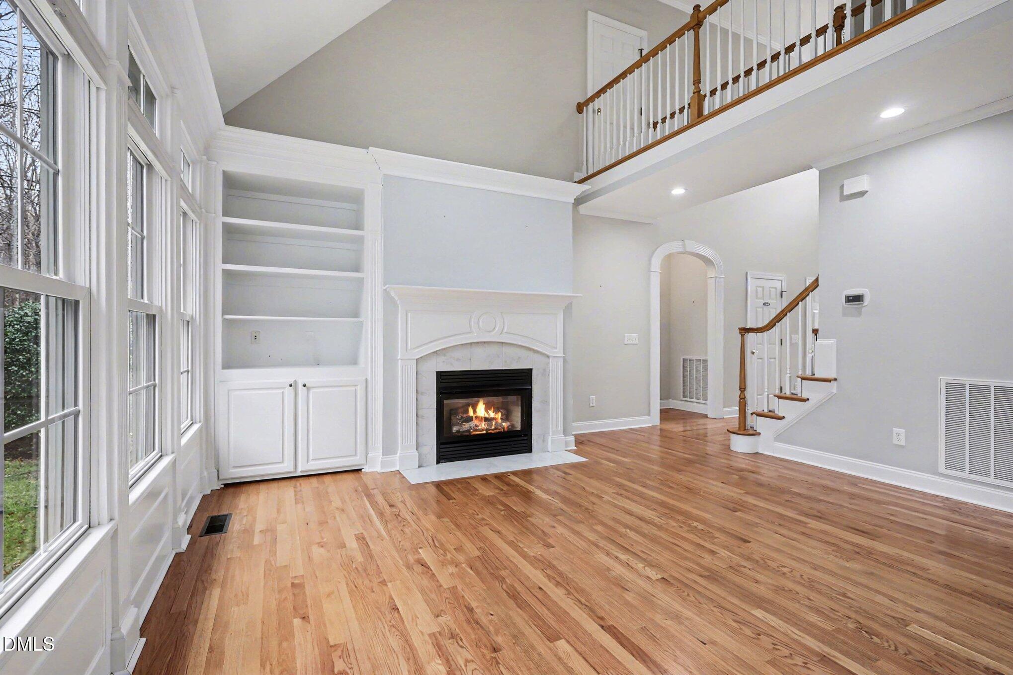 1108 Neuse Ridge Drive Clayton, NC 27527 - Photo 11 of 52 a view of an empty room with wooden floor fireplace and a window