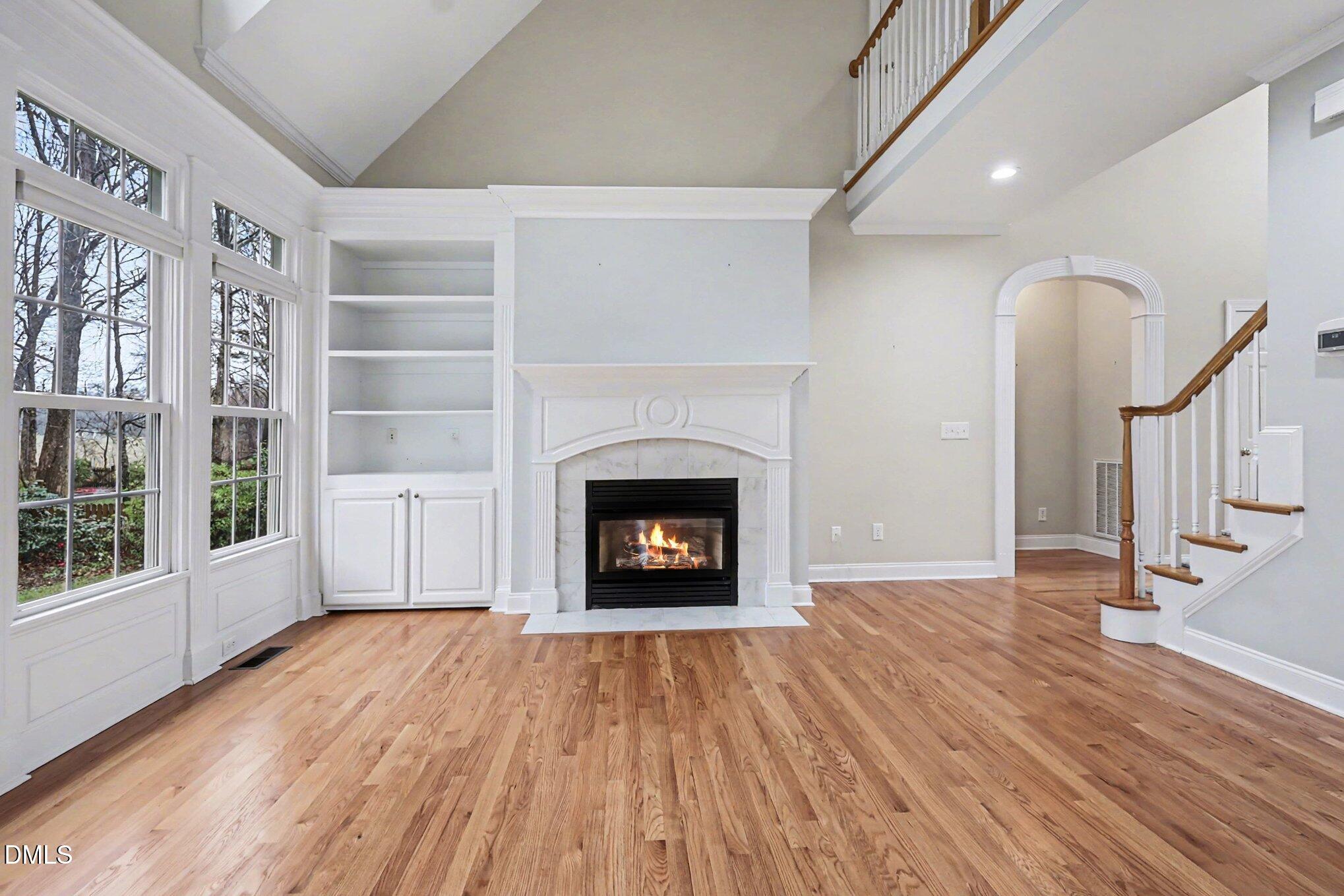 1108 Neuse Ridge Drive Clayton, NC 27527 - Photo 12 of 52 a view of an empty room with wooden floor fireplace and a window