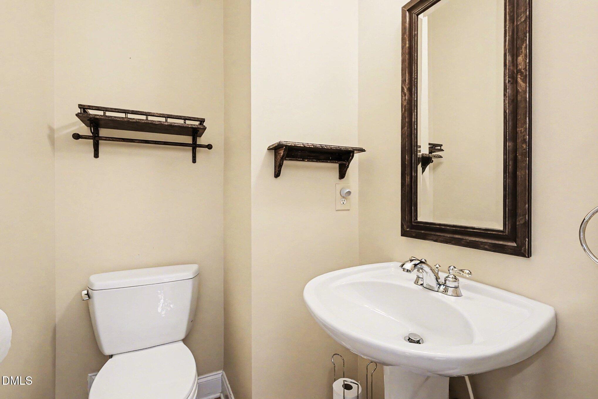 1108 Neuse Ridge Drive Clayton, NC 27527 - Photo 20 of 52 a bathroom with a toilet a sink and a mirror