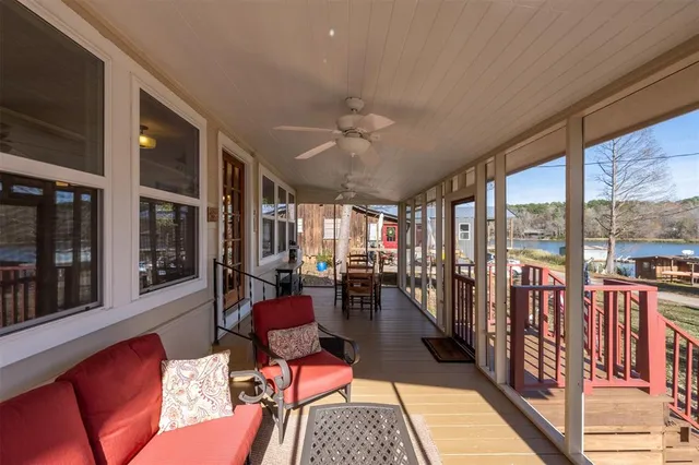 a living room with furniture floor to ceiling window and outdoor view