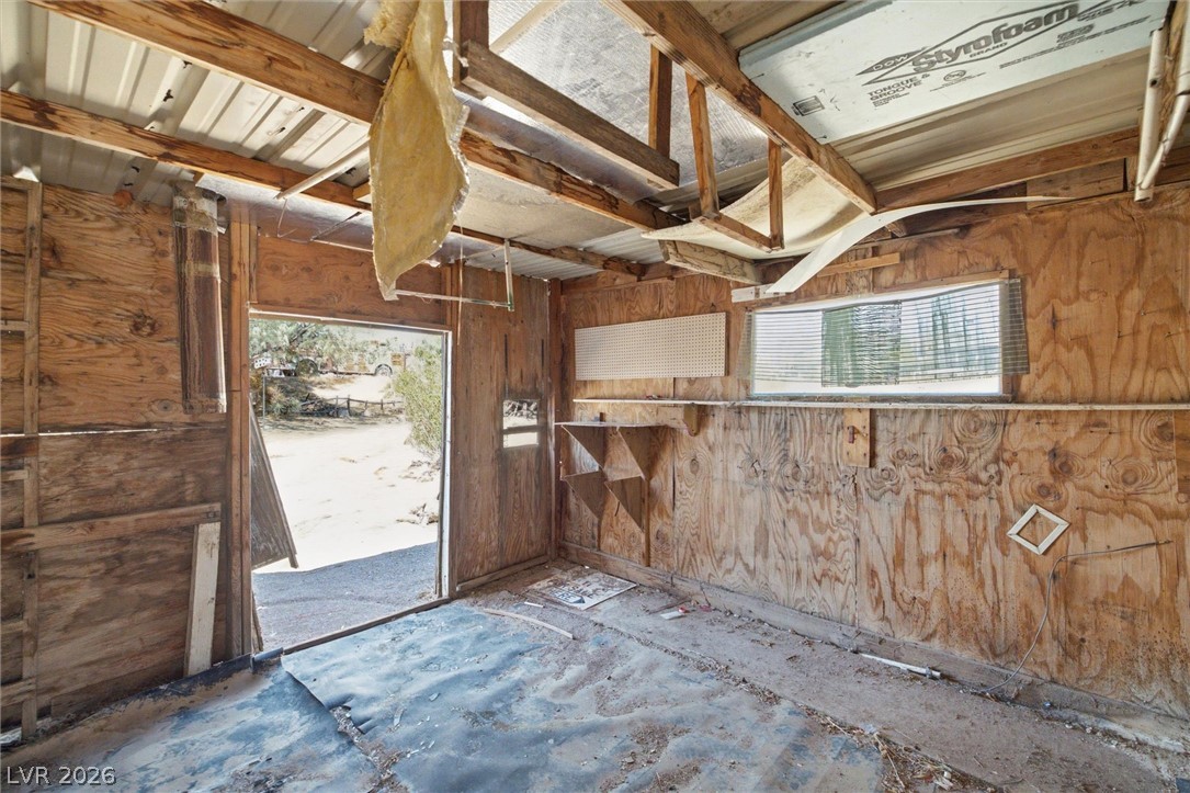 405 Main Street Beatty, NV 89003 - Photo 25 of 28 A rustic interior space awaits transformation, featuring visible wood construction and an open entryway to the outdoors.