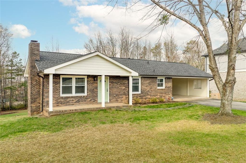 a front view of a house with a garden and trees