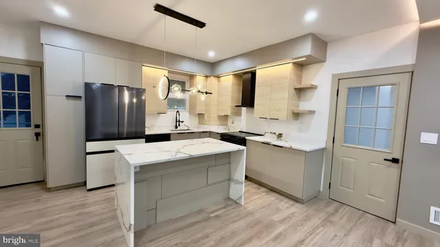 a kitchen with stainless steel appliances a refrigerator and a stove top oven