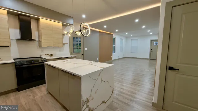 a large kitchen with stainless steel appliances a large counter top a stove and a sink