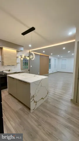 a kitchen with stainless steel appliances kitchen island granite countertop a sink stove and refrigerator
