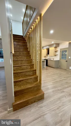 a large kitchen with kitchen island a sink dishwasher a stove and a dining table with wooden floor