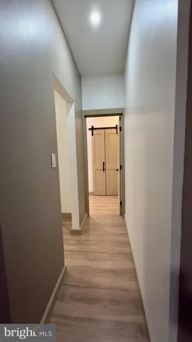 an empty room with wooden floor ceiling fan and window