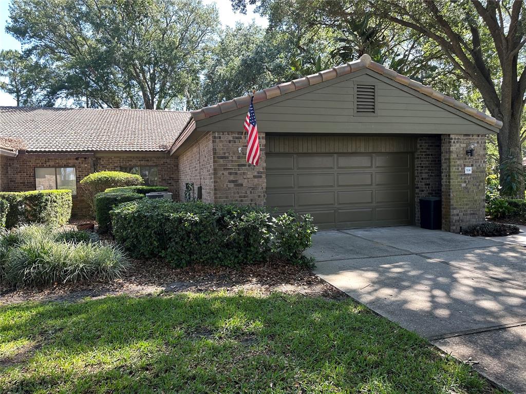 104 Woden Way Winter Haven, FL 33884 - Photo 1 of 48 a front view of a house with a garden