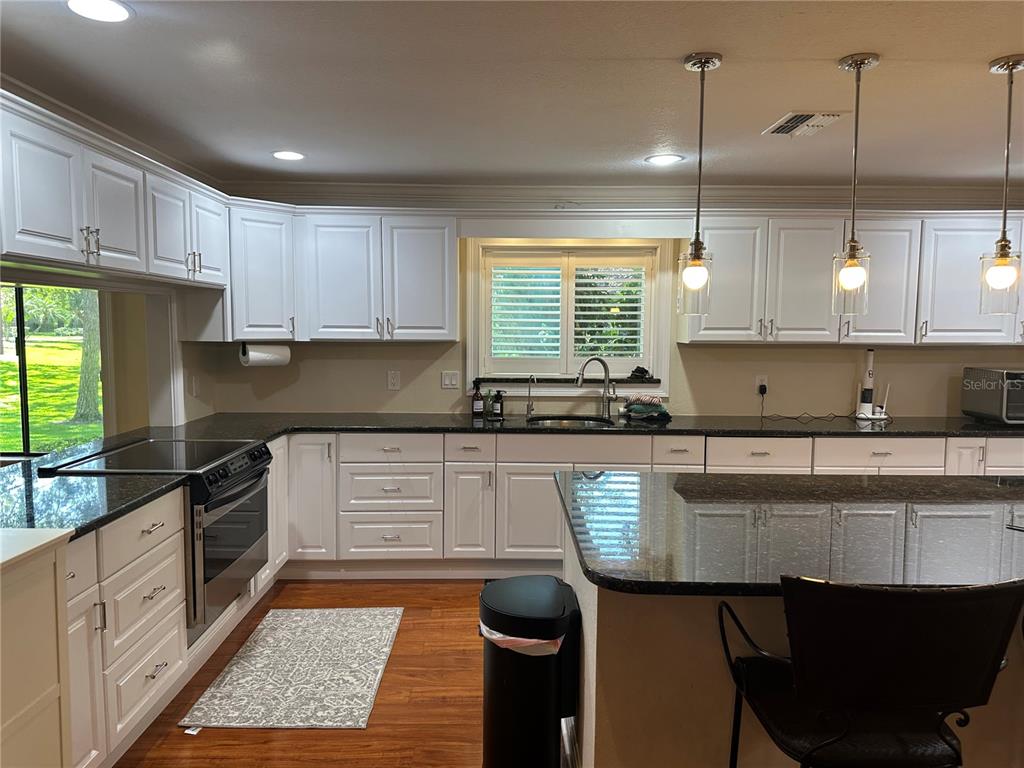 104 Woden Way Winter Haven, FL 33884 - Photo 16 of 48 a kitchen with granite countertop a sink a counter top space appliances and cabinets