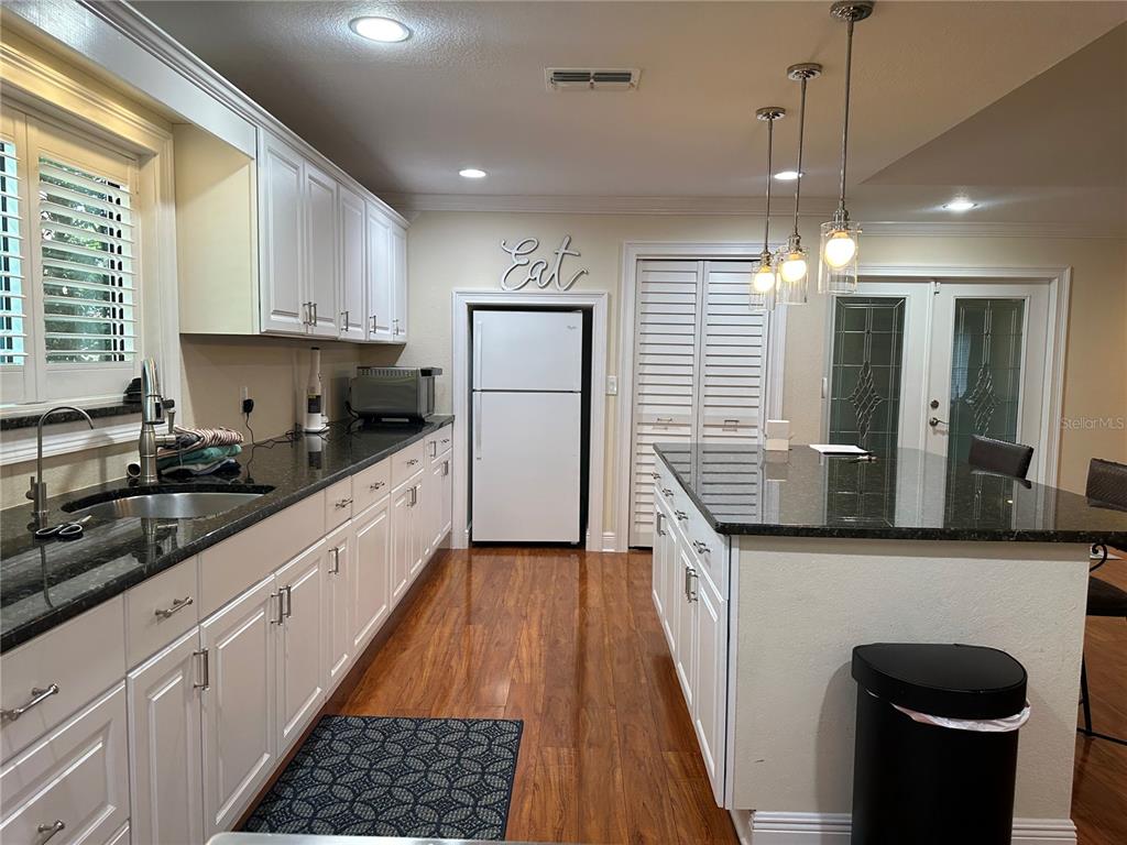 104 Woden Way Winter Haven, FL 33884 - Photo 17 of 48 a kitchen with stainless steel appliances granite countertop a sink stove and refrigerator