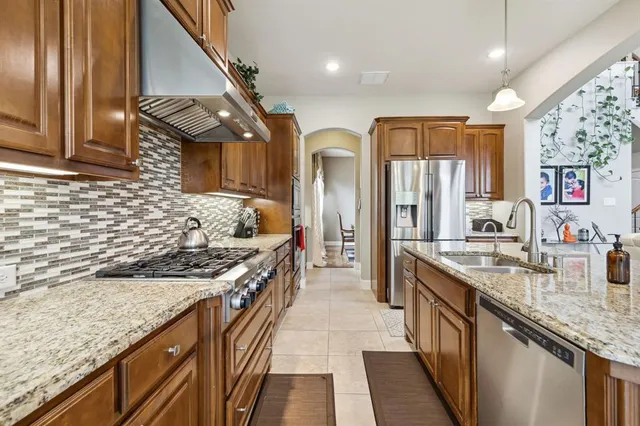a kitchen with stainless steel appliances granite countertop a sink and stove