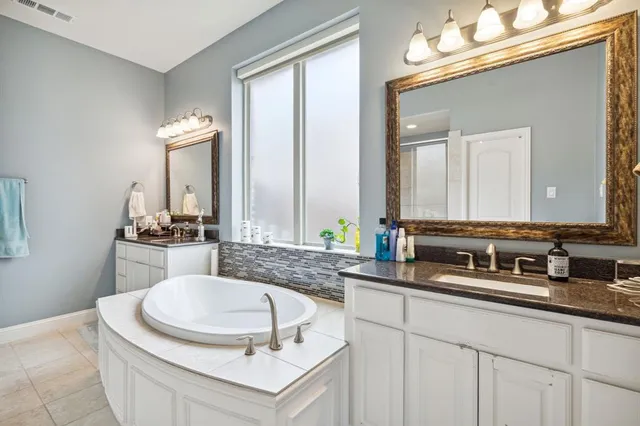 a bathroom with a double vanity sink and a mirror