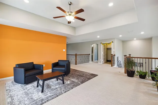 a living room with furniture and a ceiling fan