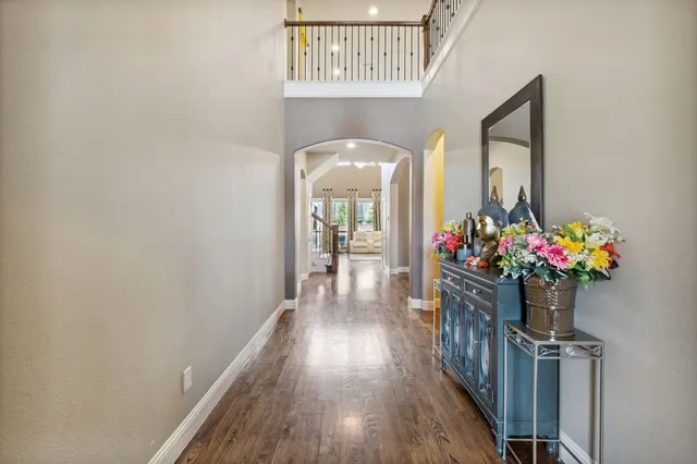 a hallway with wooden floor a chandelier and entryway