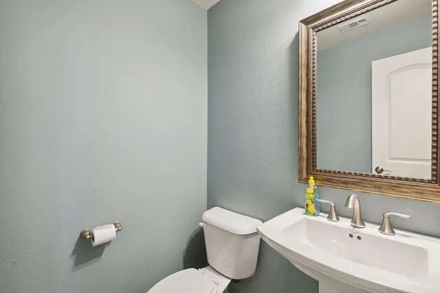 a bathroom with a sink mirror and toilet