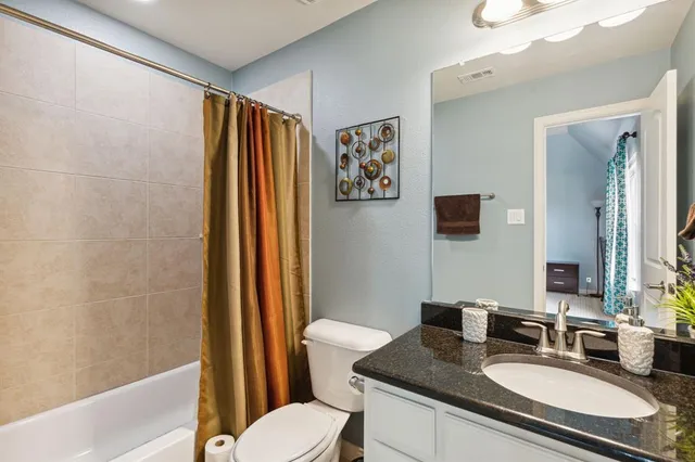 a bathroom with a granite countertop sink toilet and shower