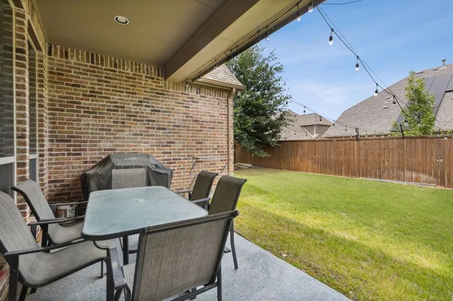 a backyard of a house with table and chairs
