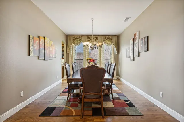 a dining room with furniture a chandelier and wooden floor