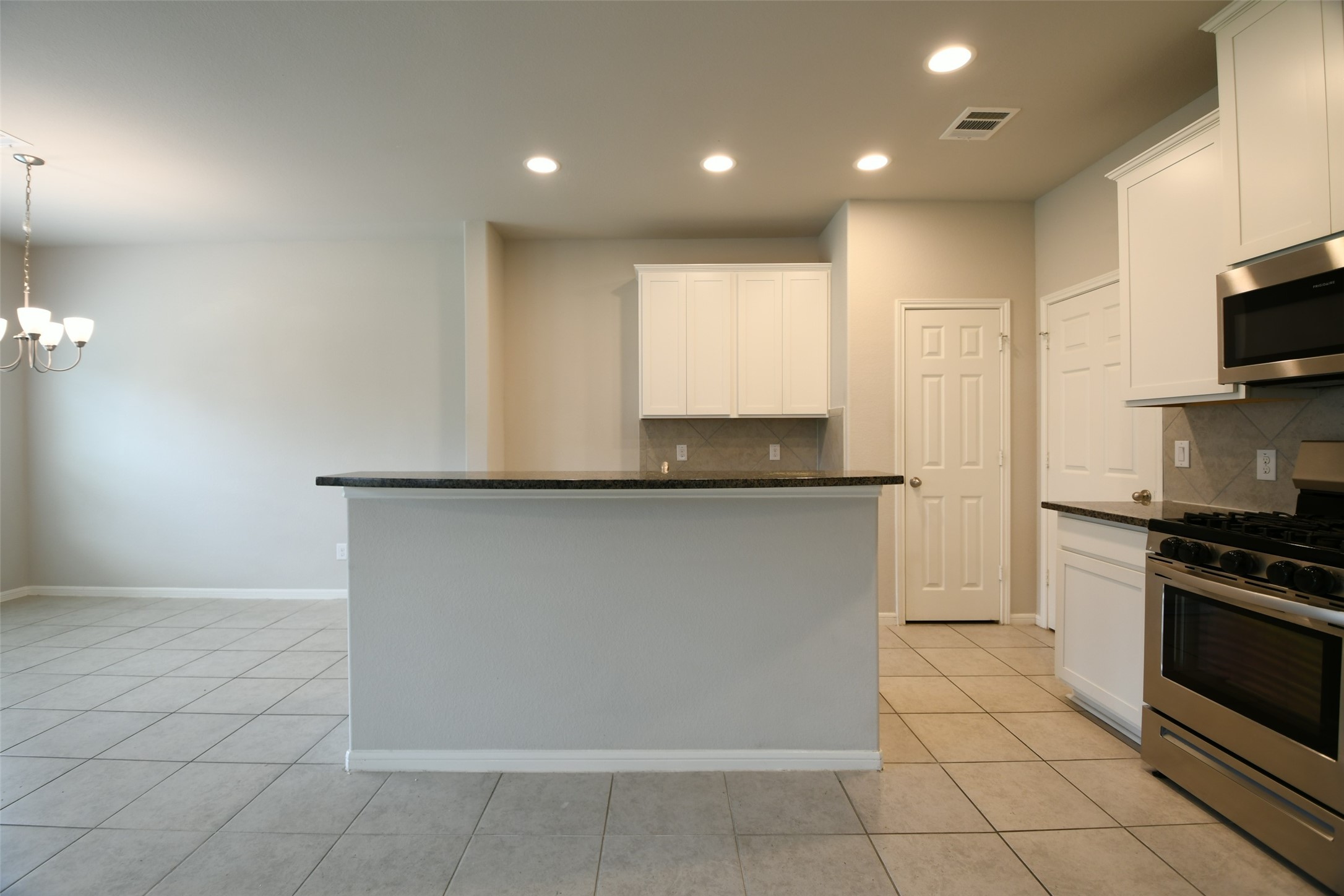 104 Camelot Pl Court Conroe, TX 77304 - Photo 13 of 34 a kitchen with kitchen island granite countertop a stove a sink and a refrigerator