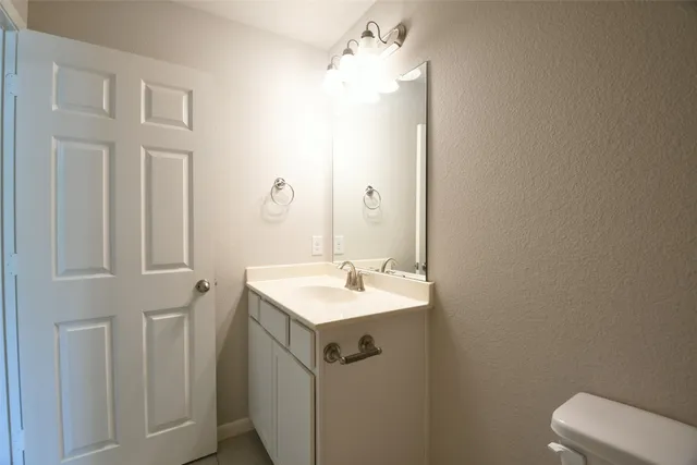 a bathroom with a sink a toilet and mirror