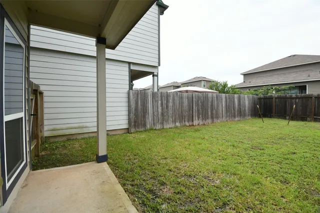 a view of a backyard with wooden fence