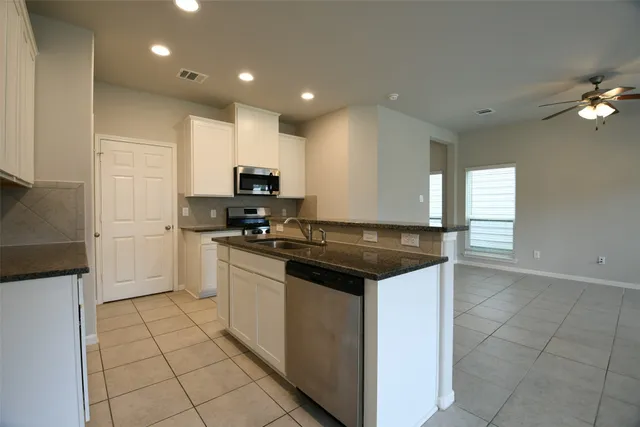 a kitchen with a sink a stove and cabinets