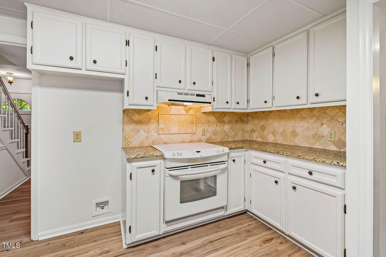 2330 Thunder Road Durham, NC 27712 - Photo 12 of 44 a kitchen with granite countertop white cabinets and white appliances