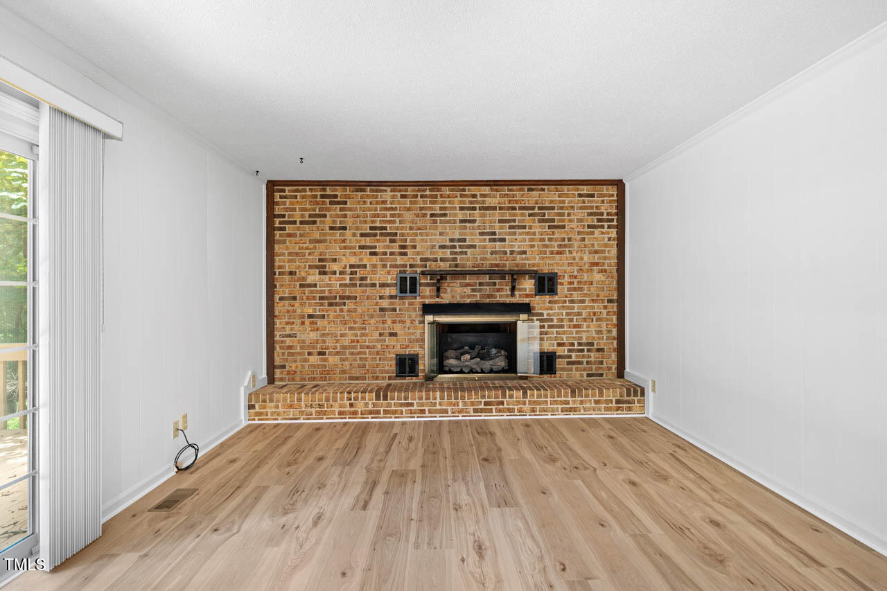 2330 Thunder Road Durham, NC 27712 - Photo 16 of 44 a view of an empty room with wooden floor fireplace and a window