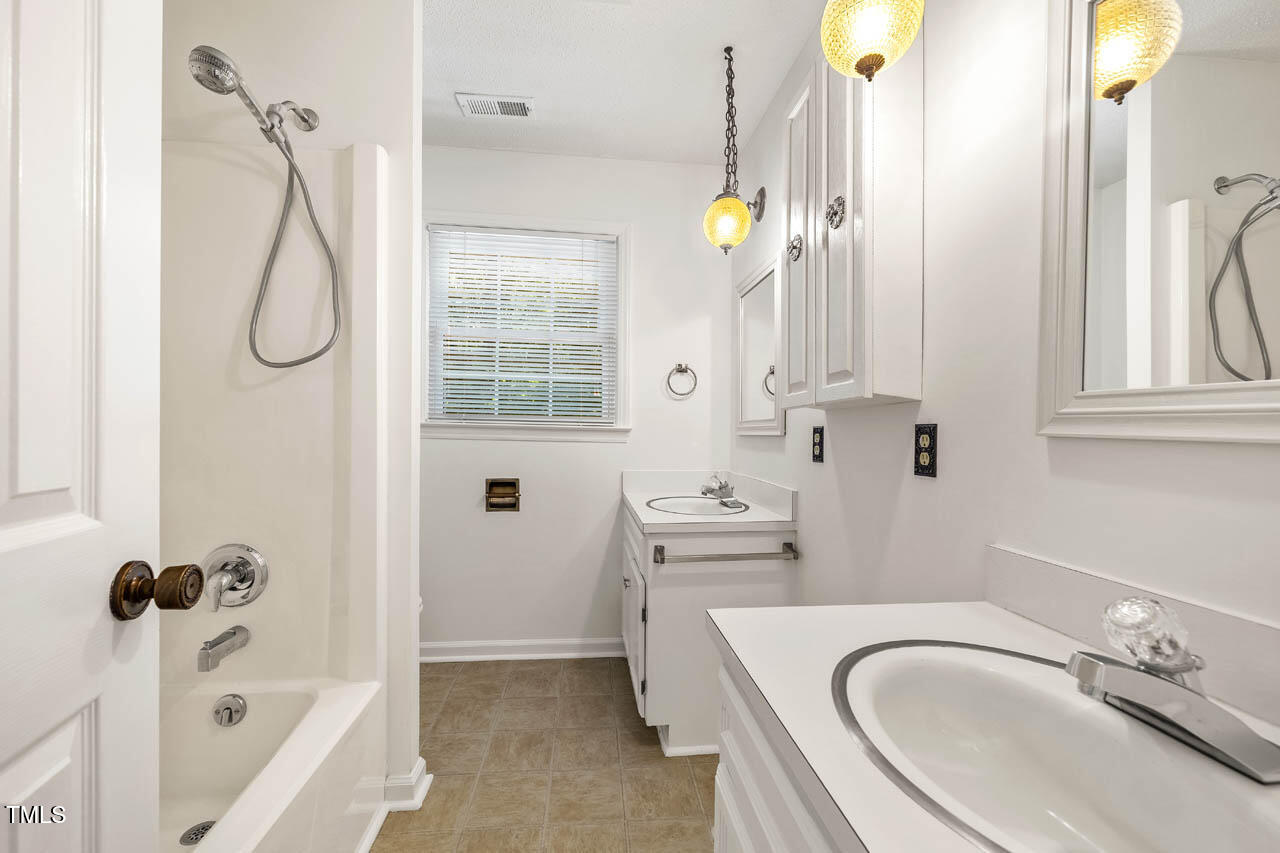 2330 Thunder Road Durham, NC 27712 - Photo 26 of 44 a bathroom with a sink a bathtub and shower