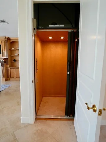 a spacious bedroom with a large bed and a chandelier