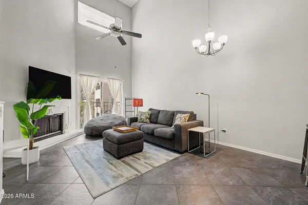 a living room with furniture a chandelier and a flat screen tv