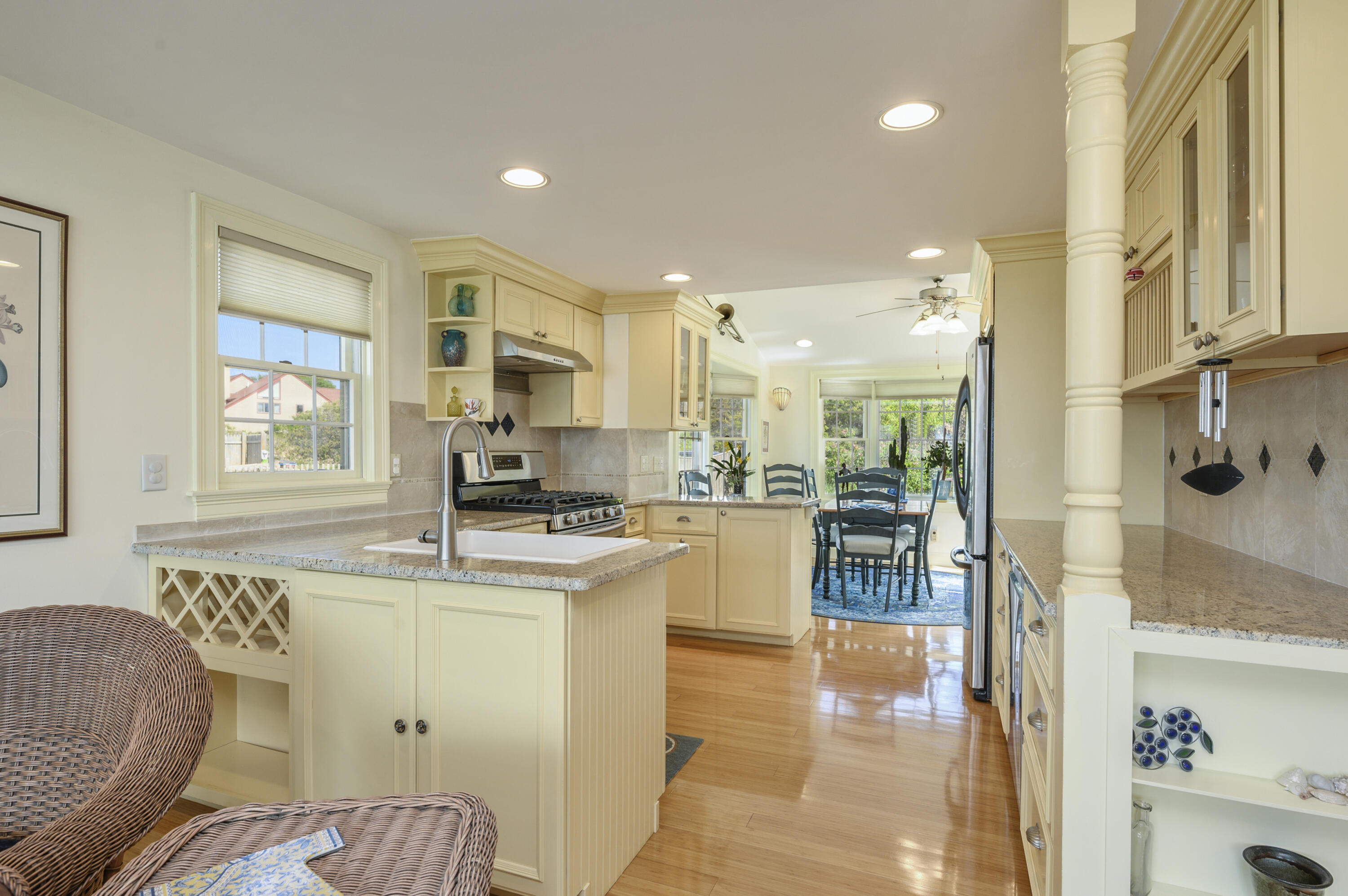51 Captain Dunbar Road Brewster, MA 02631 - Photo 13 of 36 a dining hall with stainless steel appliances granite countertop a stove a sink a refrigerator white cabinets and couches with wooden floor