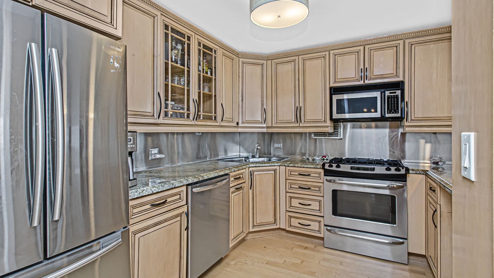 400 East Randolph Street, Unit 1915 Chicago, IL 60601 - Photo 10 of 25 a kitchen with granite countertop a stove top oven microwave and cabinets