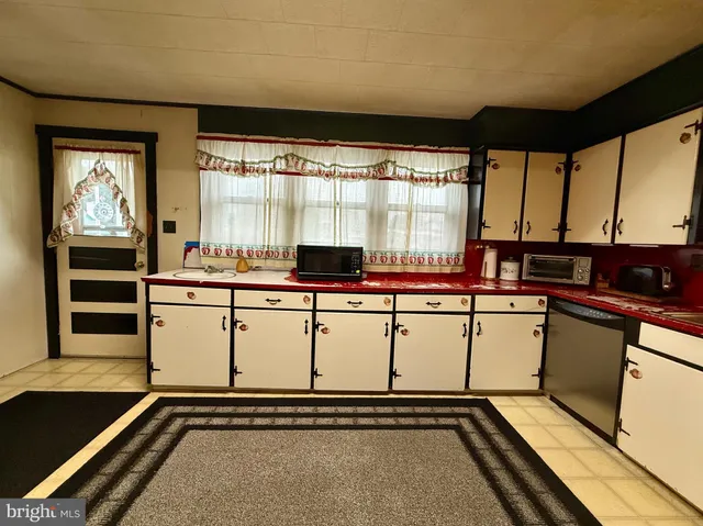 a room with table chairs and white walls