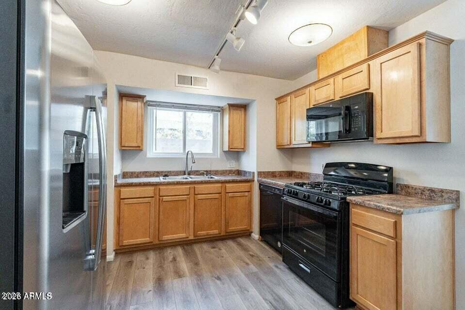 505 West Howe Street Tempe, AZ 85281 - Photo 7 of 20 a kitchen with stainless steel appliances granite countertop a stove top oven a sink dishwasher a refrigerator and a microwave oven with wooden floor