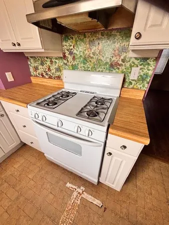 a stove top oven sitting inside of a kitchen