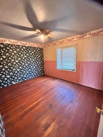 a view of an empty room with wooden floor