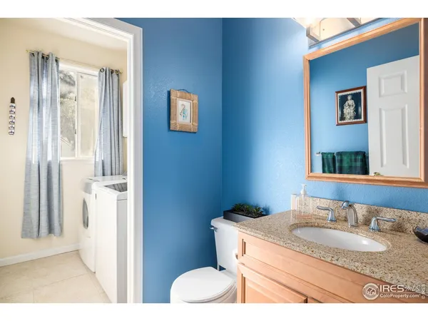 a bathroom with a granite countertop sink toilet and mirror