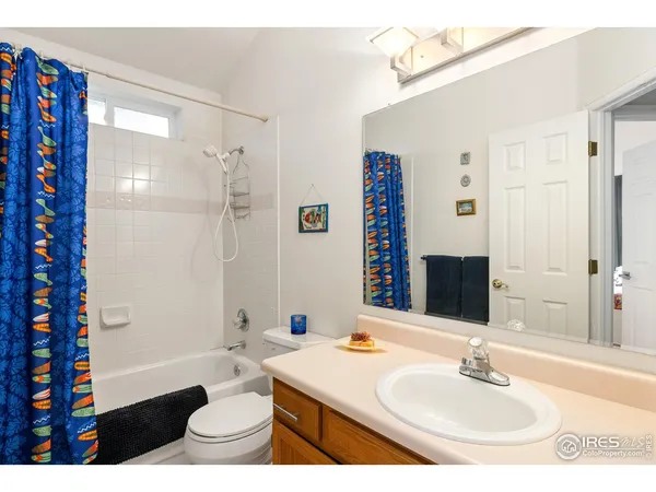 a bathroom with a sink a toilet a mirror and shower