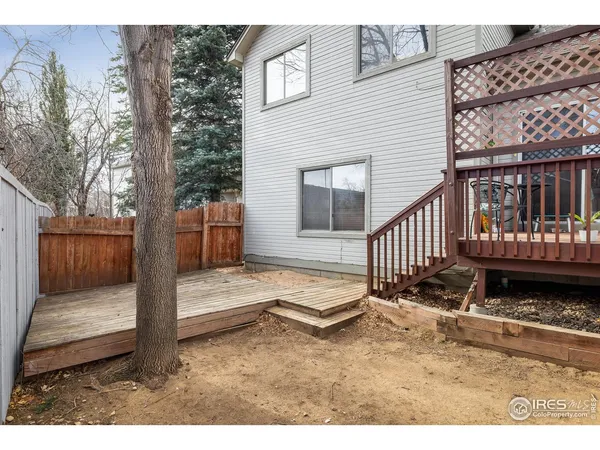a view of a house with backyard and wooden fence