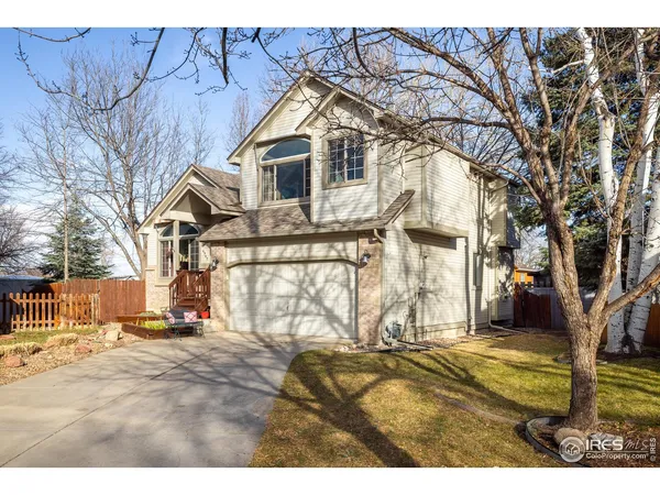 a view of a white house with a large tree