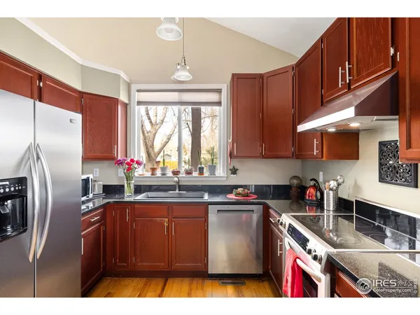 a kitchen with stainless steel appliances granite countertop a sink dishwasher stove refrigerator and cabinets