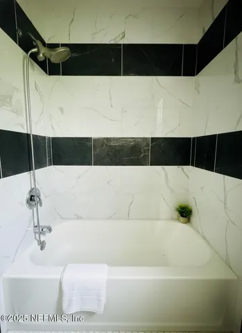 a bathroom with a bathtub and shower