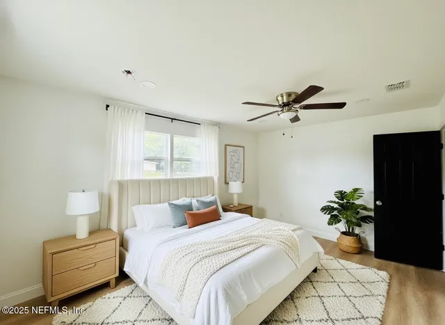 a bedroom with a bed and a potted plant
