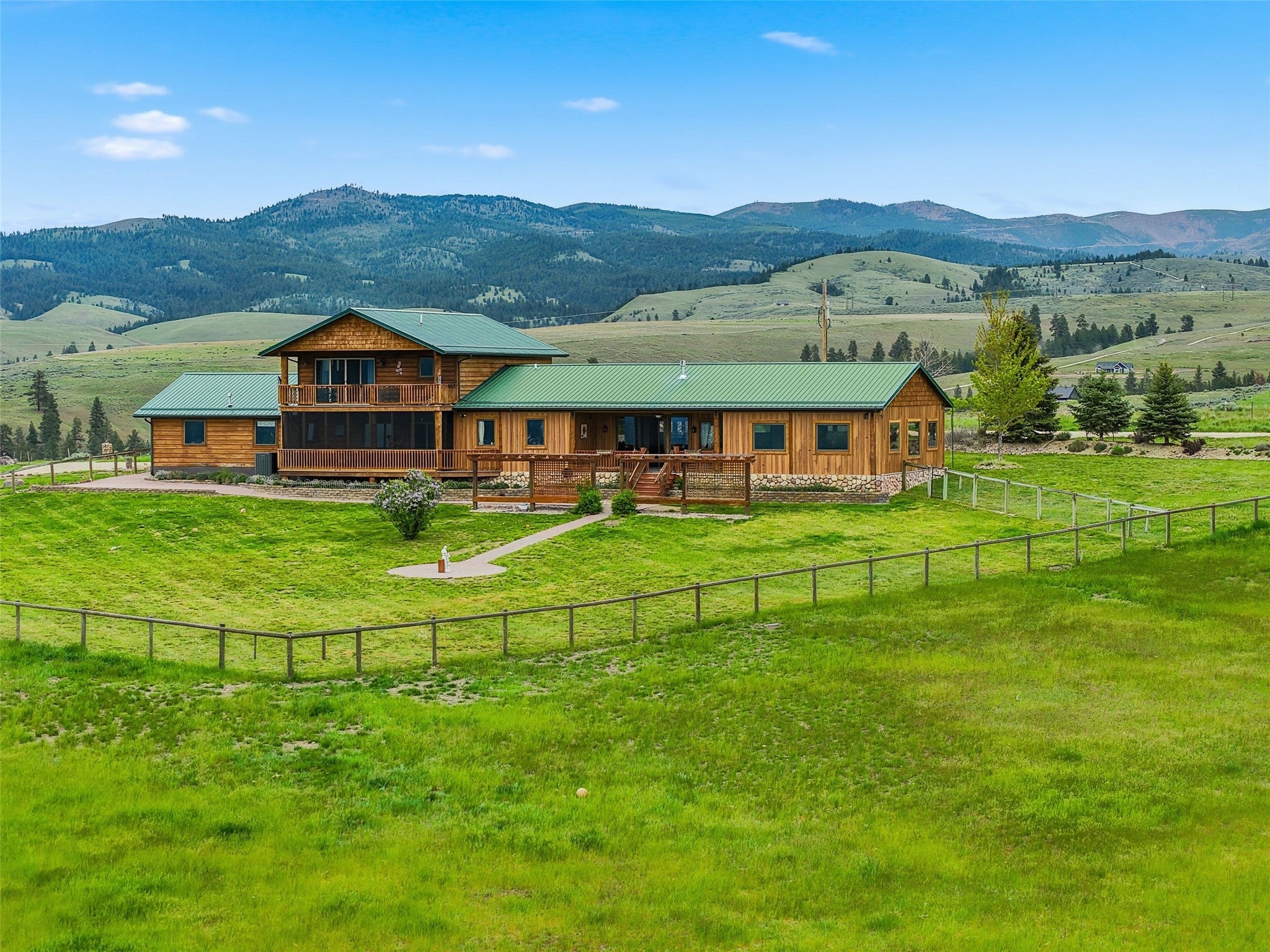 679 Hidden Valley Road North Florence, MT 59833 - Photo 80 of 85 Wood-sided residence featuring a green metal roof and a spacious wraparound deck