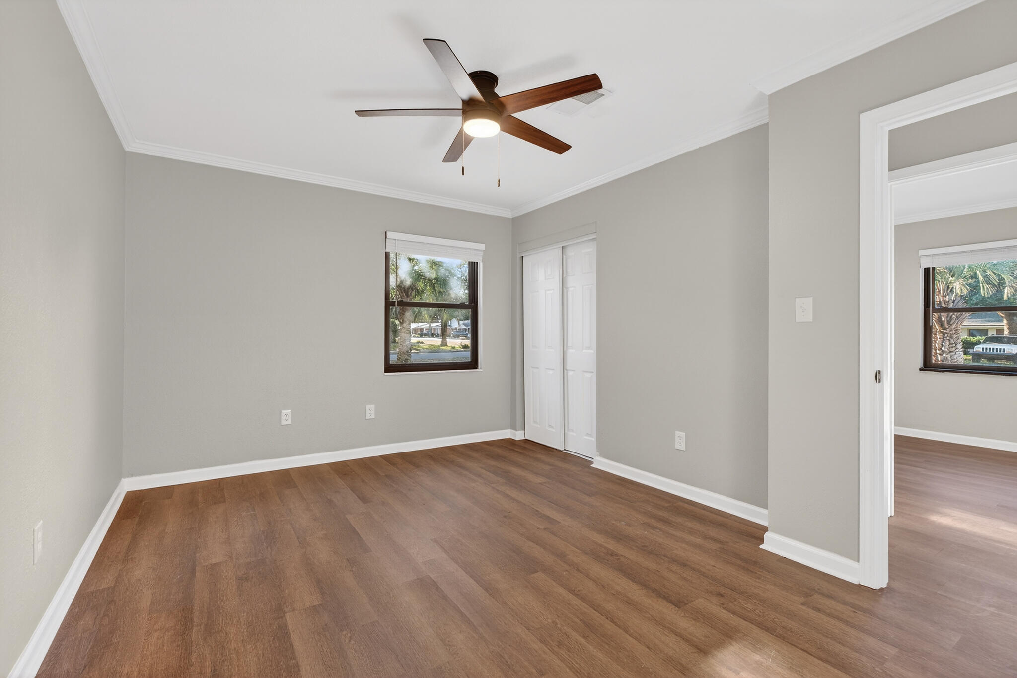 420 Paradise Road Niceville, FL 32578 - Photo 20 of 38 an empty room with wooden floor ceiling fan and windows